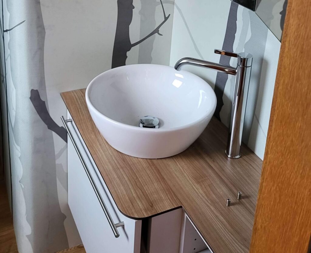 Renovation Romanshorn | Badmöbel aus Holz mit Wasserhahn und weissem Waschbecken