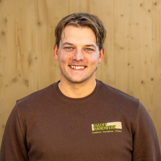 Team Egloff Handwerk | Theo mit Holzbrett als Hintergrund