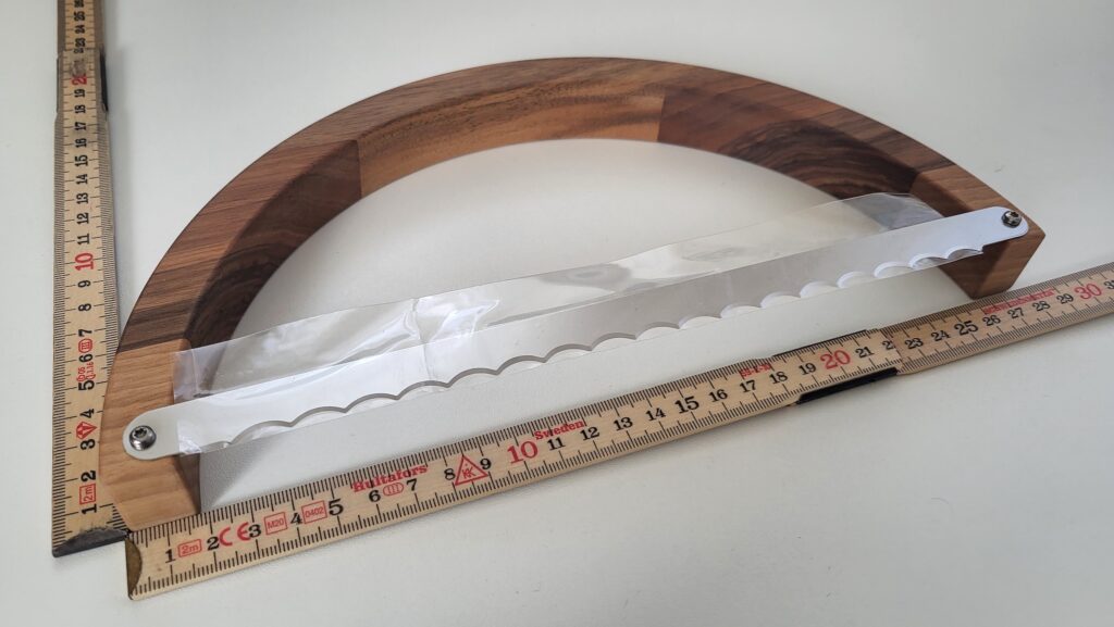 Runde Brotsäge aus Holz mit Meterstab damit man die Masse sehen kann.