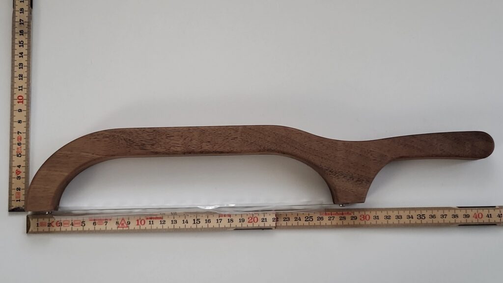 Flache Brotsäge aus Holz mit Meterstab damit man die Masse sehen kann.