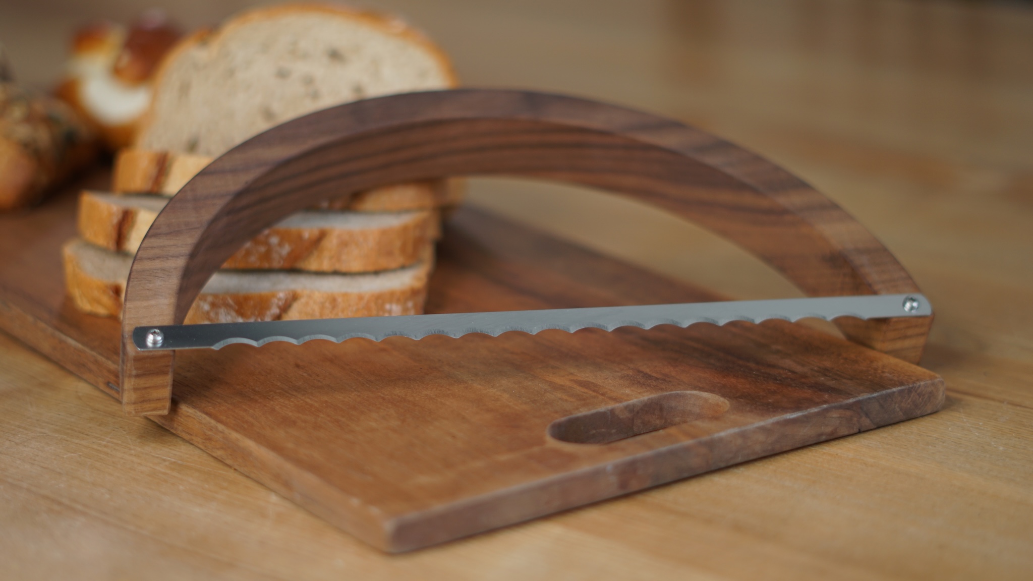Brotsäge auf einem Schneidebrett und Brot