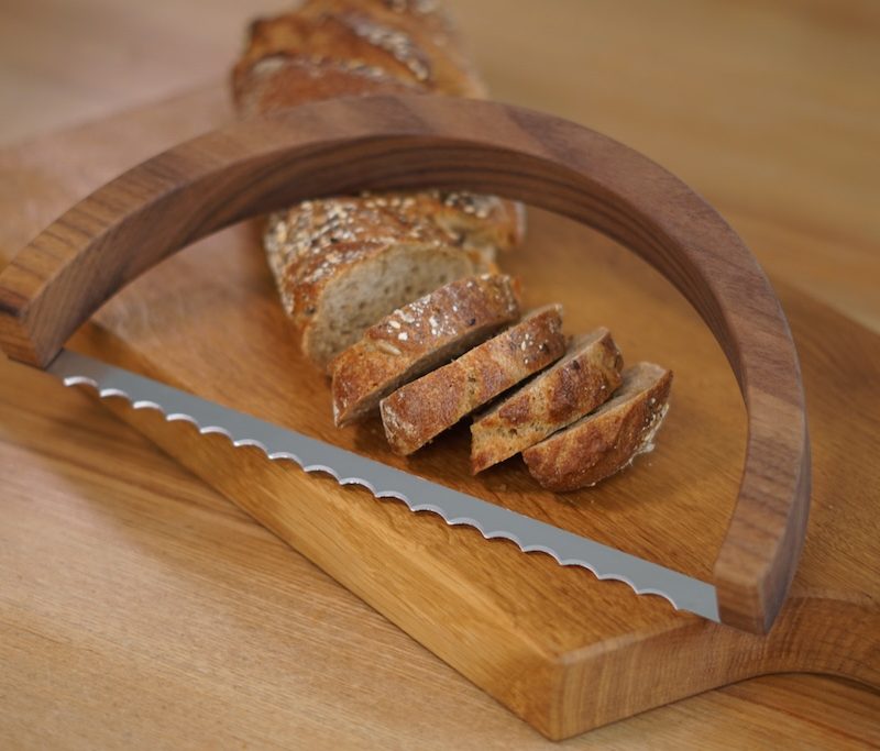 Brotsäge mit Brot auf einem Schneidebrett